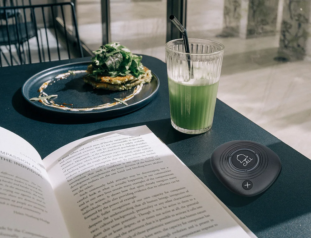 TableTap Pebble wireless call button on a café table in use